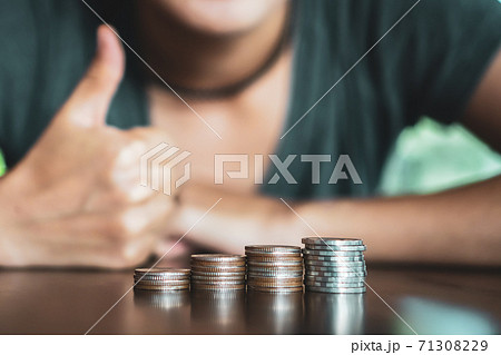 Gold coins on table and green nature bokeh background. 71308229