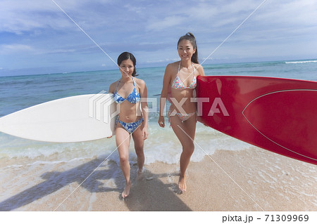 サーフィンをする日本人女性の写真素材