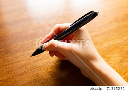 右手でペンを持つの写真素材