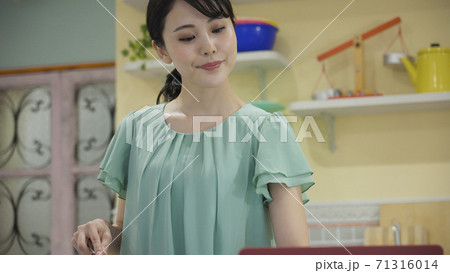 レシピサイトを見ながら料理をする若い女性 レシピサイトを見ながら料理をする若い女性 71316014