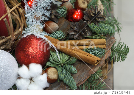 Christmas or New Year composition. Wicker basket with fir branches decorated by natural materials on grey background 71319442