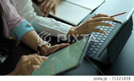 Two female workers working together on their project with digital devices 71321858