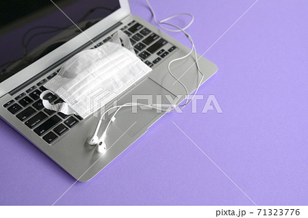 Ear phones on top of computer laptop and face mask Ear phones on top of computer laptop and face mask 71323776