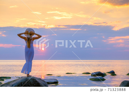 Tranquil woman in summer dress at seaside Tranquil woman in summer dress at seaside 71323888