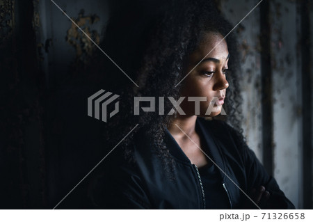 Portrait of sad mixed-race teenager girl standing indoors in abandoned building. 71326658