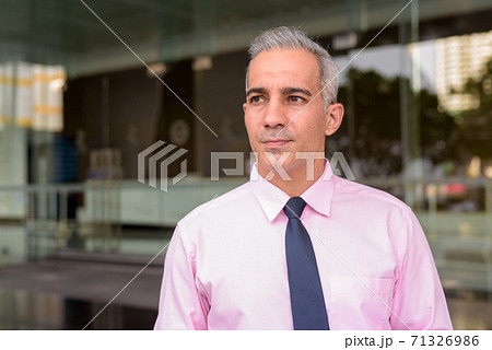 Face of handsome Persian businessman thinking outside modern building Face of handsome Persian businessman thinking outside modern building 71326986