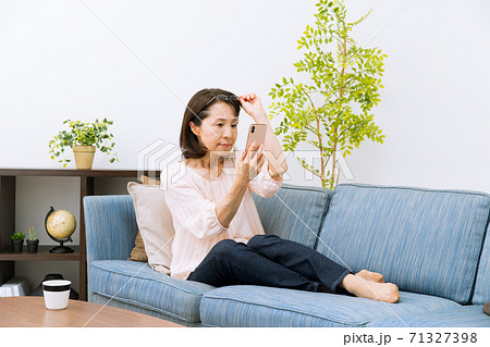 老眼鏡でスマートフォンを見る女性 老眼鏡でスマートフォンを見る女性 71327398