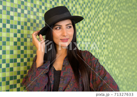 Portrait of beautiful young woman thinking against colorful wall 71327633