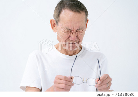 目頭を押さえるシニア男性 目頭を押さえるシニア男性 71328030