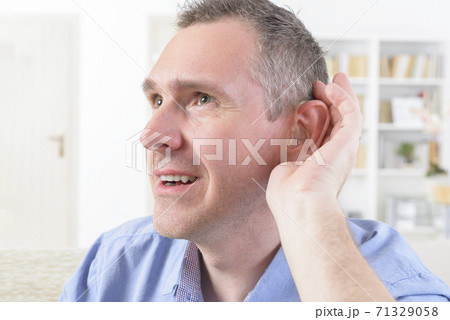 Man wearing deaf aid 71329058