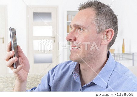 Deaf man using sign language on the smart phone 71329059