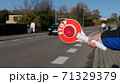 A little boy holds a stop sign at a pedestrian crossing 71329379