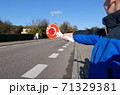 A little boy holds a stop sign at a pedestrian crossing 71329381
