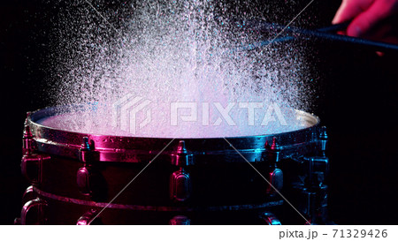 Freeze motion of drummer hitting drum with water splashes Freeze motion of drummer hitting drum with water splashes 71329426