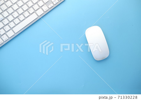 Top view of computer mouse, keyboard on blue background, 71330228