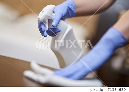 Maid disinfecting bedside table in the bedroom Maid disinfecting bedside table in the bedroom 71334620