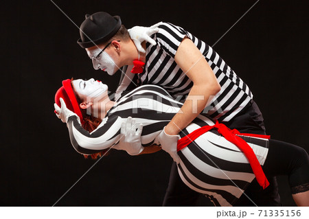 Portrait of two mime artists performing, isolated on black background. Man leaning his woman while dancing. Symbol of passion, pair dancing, embrace Portrait of two mime artists performing, isolated on black background. Man leaning his woman while dancing. Symbol of passion, pair dancing, embrace 71335156