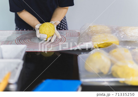 Woman hands preparing bread dough on black marble table. 71335250