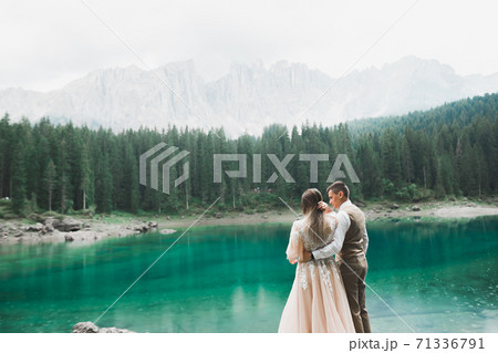 Beautiful modern couple near a lake in the mountains make wedding photos 71336791