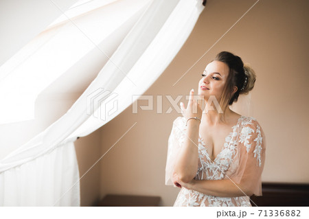 Gorgeous bride in robe posing and preparing for the wedding ceremony face in a room 71336882