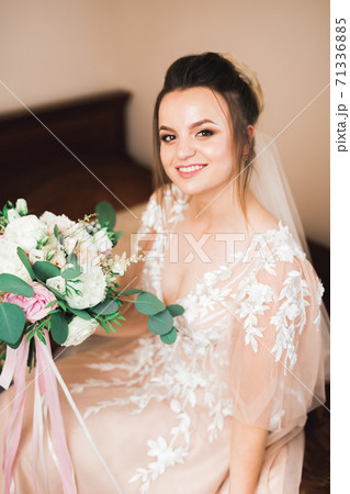 Beautiful bride wearing fashion wedding dress with feathers with luxury delight make-up and hairstyle, studio indoor photo shoot 71336885