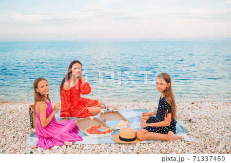 Family having a picnic on the beach 71337460