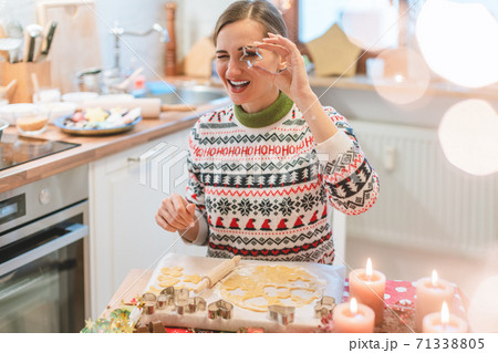 Woman in the Christmas kitchen posing with cookie cutter Woman in the Christmas kitchen posing with cookie cutter 71338805