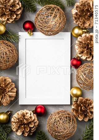 Christmas composition with empty picture frame. Golden ornament, pine cones and fir needles decorations. Mock up greetings card template 71340575