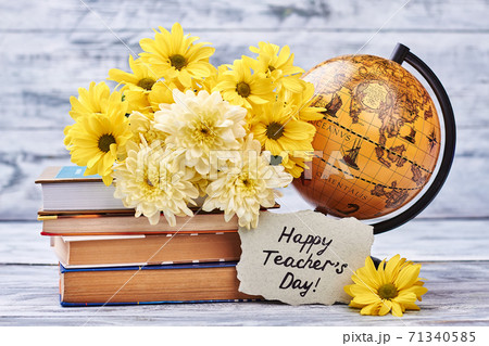 Yellow chrysanthemums, books and globe. Yellow chrysanthemums, books and globe. 71340585