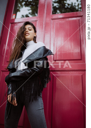 Young woman outdoor against a red door Young woman outdoor against a red door 71341180