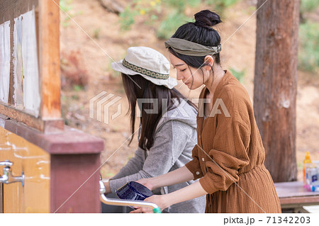 キャンプ場の洗い場でお皿や食器を洗うアジア人女性 キャンプ場の洗い場でお皿や食器を洗うアジア人女性 71342203