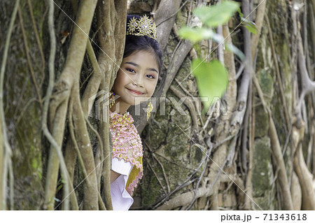 A portrait of a Thai girl wearing a traditional Thai dress with an old church of an old Thai temple. A portrait of a Thai girl wearing a traditional Thai dress with an old church of an old Thai temple. 71343618