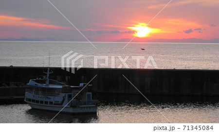 村上市桑川漁港で夕日と遊覧船 71345084