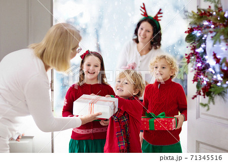Family on Christmas day. Kids with gifts at door. 71345516