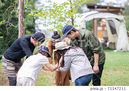 キャンプ場などのアウトドアで友達や仲間と円陣を組むアジア人の男女 キャンプ場などのアウトドアで友達や仲間と円陣を組むアジア人の男女 71347211