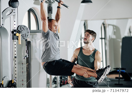Mature man exercising with trainer Mature man exercising with trainer 71347972