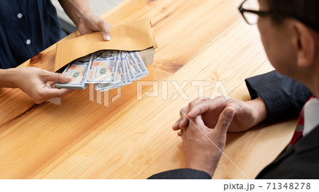 Businessman reciving money United States Dollars bills to corruption from his partner in business at working desk - bribery concept. 71348278