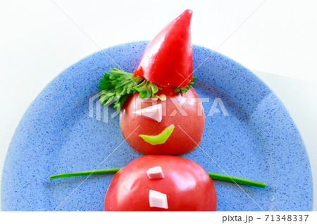 Snowman of tomatoes, peppers, ham and herbs on a plate. Christmas decor from food. Isolated on a white background. Copy space 71348337