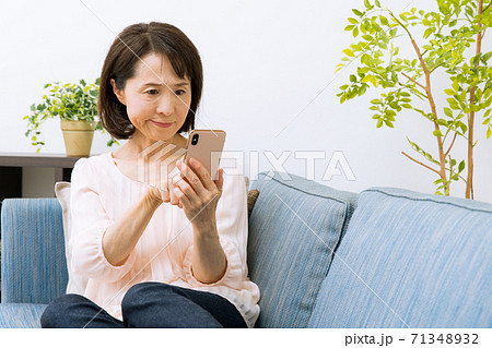 スマートフォンを見る女性　驚く　困る 71348932