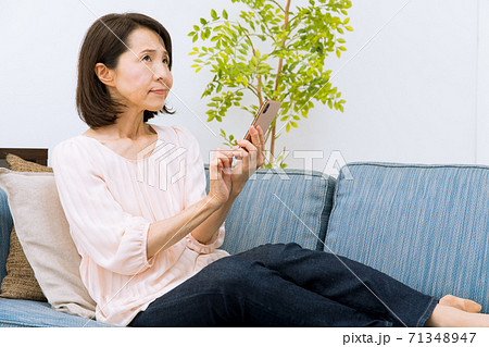 スマートフォンを見る女性　驚く　困る 71348947