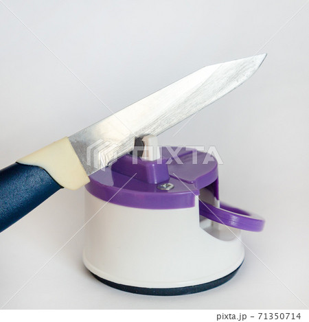 Kitchen knife and compact knife sharpener on white background Kitchen knife and compact knife sharpener on white background 71350714