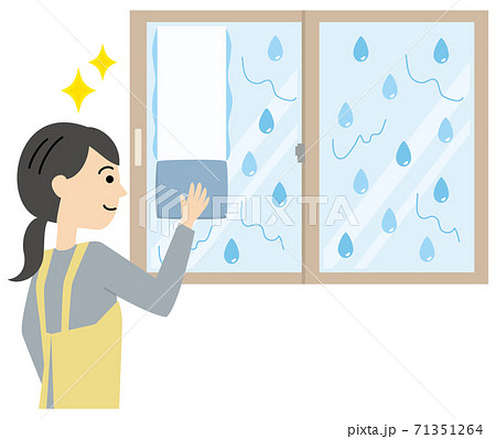 結露で濡れた窓を拭くエプロンの女性 71351264