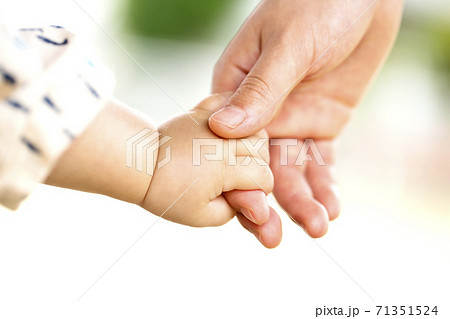 母親と赤ちゃんが手をつなぐ 親子の触れ合いの写真素材