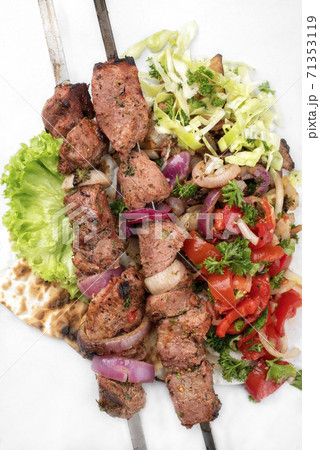 Traditional Greek souvlaki barbecue skewer with cabbage and tomato onion salad 71353119