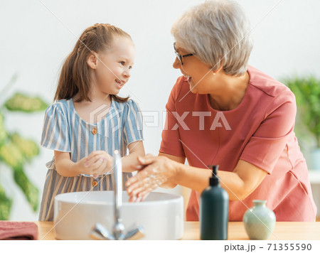 girl and her grandmother are washing hands 71355590