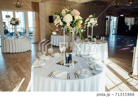 Luxurious restaurant. Luxurious interior, white tables, serving dishes and glasses for guests 71355866