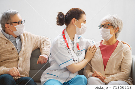 Doctor and senior couple wearing facemasks 71356218