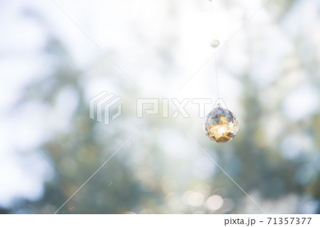 美しいガラスのクリスタルのサンキャッチャーの飾りがある窓辺 美しいガラスのクリスタルのサンキャッチャーの飾りがある窓辺 71357377