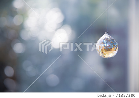 美しいガラスのクリスタルのサンキャッチャーの飾りがある窓辺 美しいガラスのクリスタルのサンキャッチャーの飾りがある窓辺 71357380