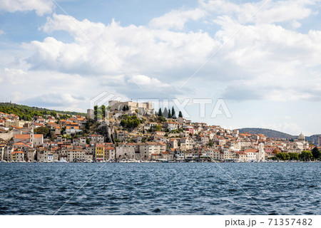 Sea view of Sibenik, Croatia, with a medieval fortress on a hill against the sky with clouds 71357482